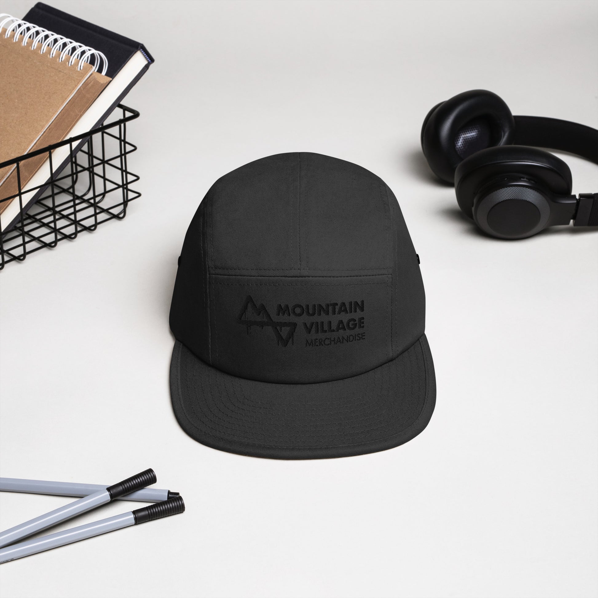 Five panel camper style hat sitting on desk